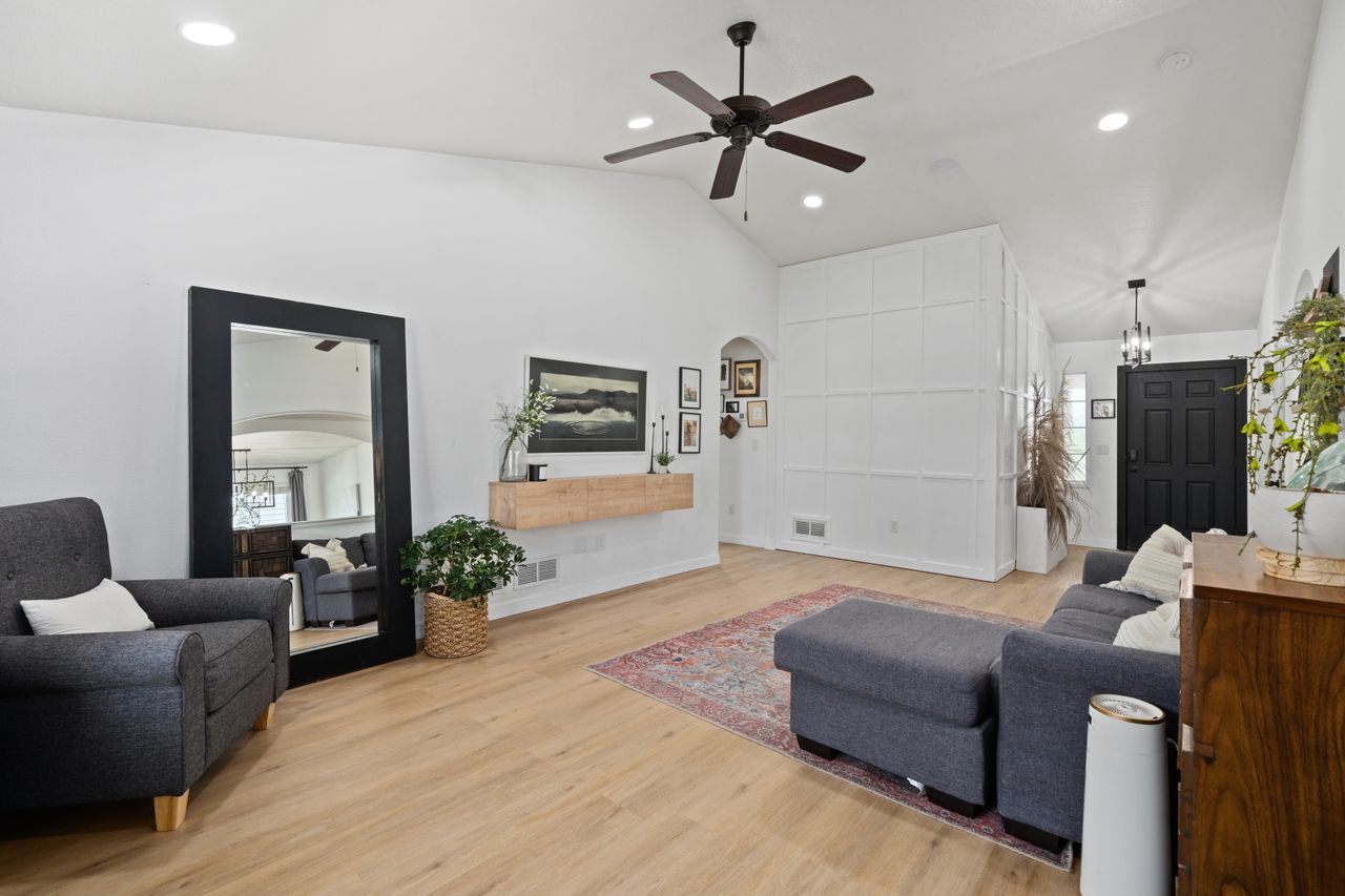 Spacious, stylish living room featuring modern furniture, decor, and lighting for a cozy and elegant atmosphere.