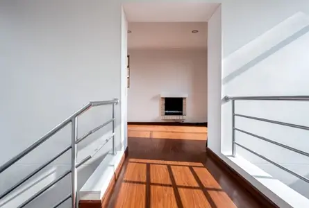 Bright, freshly painted white hallway and stairwell in a modern home.